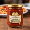 パスタを背景に、木のテーブルに置かれたタジャスカオリーブとケッパー入りトマトソース180gの瓶